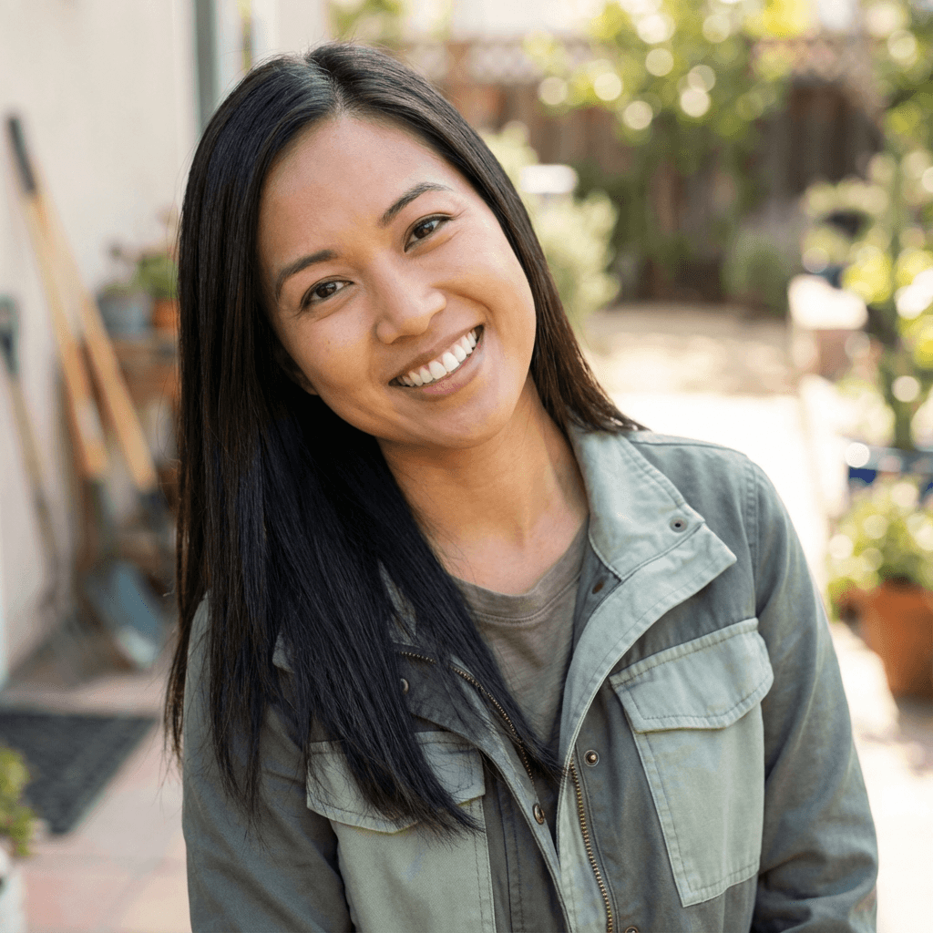 Female service advisor smiling at the front desk of a busy auto shop